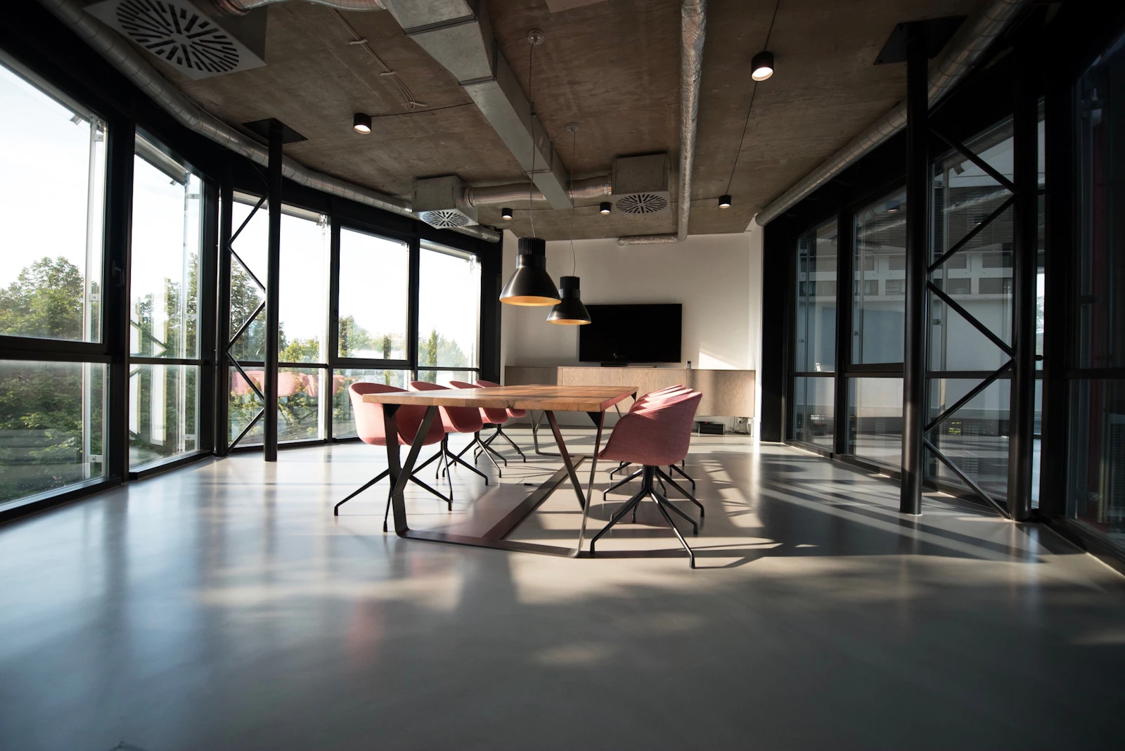 Espaço de trabalho amplo e silencioso, com mesas organizadas e luz natural